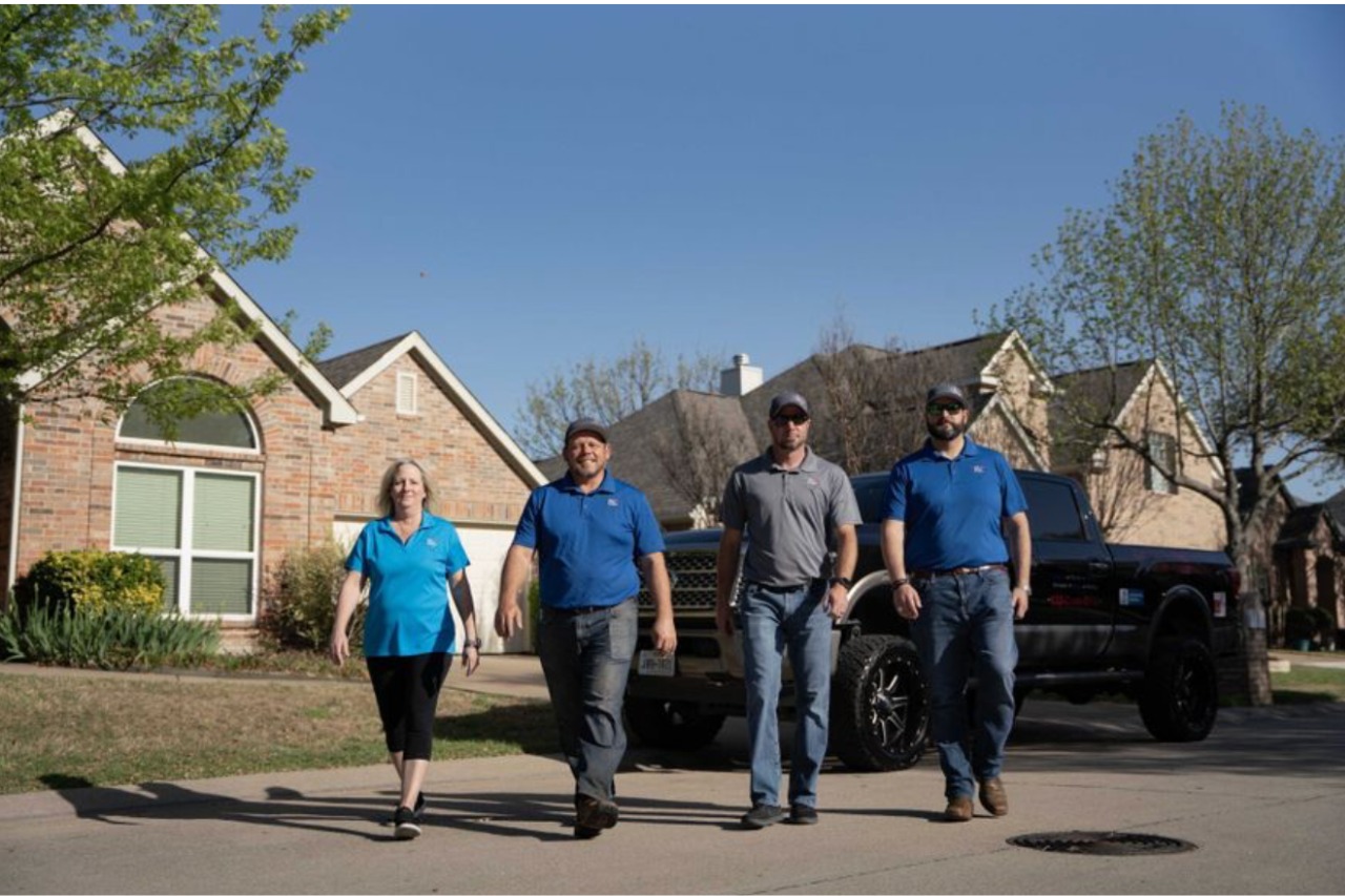 Cooks DFW Roofing & Restoration Team in front of roofing projects in Dallas, Texas
