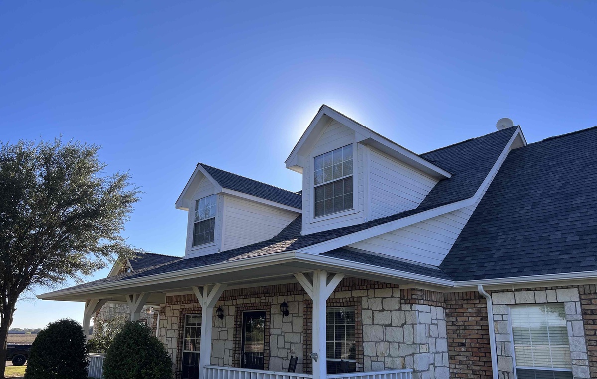 roof on house in anna with two window and blue sky